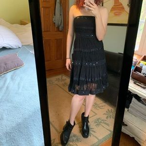 Knee length black strapless dress.